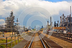 Oil and Gas Refinery Distillation Towers with Railroad Tracks and a Distant City photo