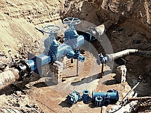 Oil, gas, water industry. Wellhead with valve armature underground. Dug deep trench