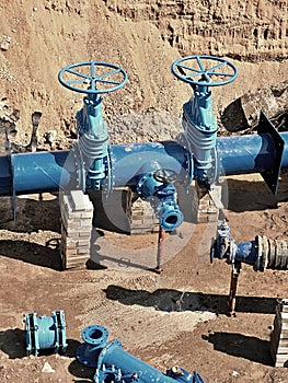 Oil, gas, water industry. Wellhead with valve armature underground. Dug deep trench