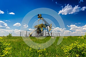 Oil and gas well profiled on blue sky with cumulus clouds, in Europe