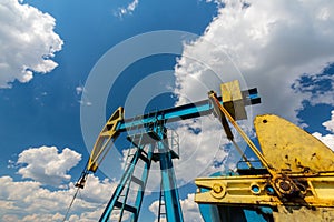 Oil and gas well profiled on blue sky with cumulus clouds, in Europe