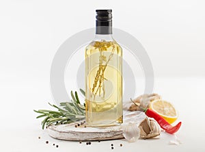 Oil with herbs in the bottle of salad on white