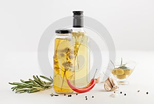 Oil with herbs in the bottle of salad on white