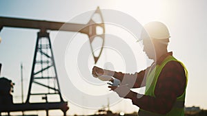 oil industry. engineer next to an oil rig signs a paper contract. oil production business finance concept. gas