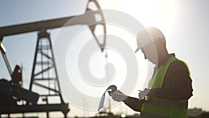 oil industry. engineer next to an oil rig signs a paper contract. oil production business finance concept. gas