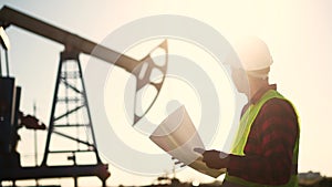 oil industry. engineer next to an oil rig signs a paper contract. oil production business finance concept. gas