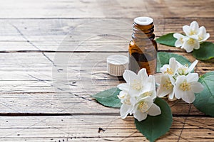 Oil of jasmine. Aromatherapy with jasmine oil. Jasmine flowers. Wooden background with copy space