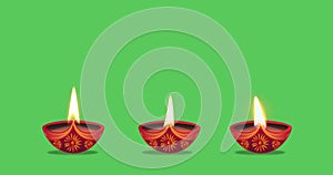 Oil lamps burning in three different ways on a green background. Diwali celebration, festival of lights, Karthika Deepa Festival