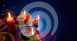 Oil lamps lit on colorful rangoli photo