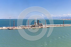 Oil loading and discharge station for tanker ships in a harbor