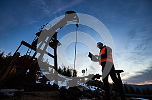 Oil man controlling work of petroleum pump jack.