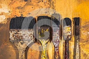 Oil paint brushes on wood painted background