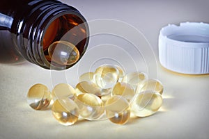 Oil pills spilling out of prescription bottle on table