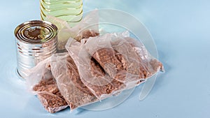 Oil in a plastic bottle, buckwheat and a can of canned food on a blue background