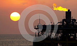 Oil platform and flare at sunset