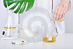 Oil pouring, Alternative herbal medicine, Mortar with healing botanical herbs, Natural organic botany and scientific glassware