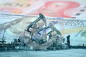 Oil pump on background of US dollar and RMB