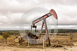Oil pump with cloudy sky in the Las Loras oil field in Burgos. Located in the north of Spain. Castilla and Leon