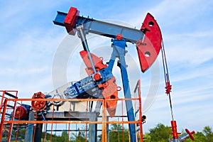 The oil pump, industrial equipment. Oil field site, oil pumps are running. Rocking machines for oil production in a