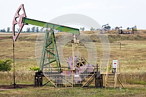 Oil pump jack in operation, meadows of Bashkiria, oil and gas industry
