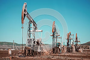 Oil pump jack rocking with pipeline in the background. Rocking machines for power generation. Extraction of oil.