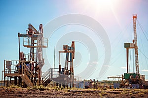 Oil pump jack rocking with pipeline in the background. Rocking machines for power generation. Extraction of oil.