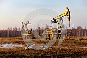 Oil pump jack rocking with pipeline in the background. Rocking machines for power generation. Extraction of oil