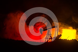 Oil pump oil rig energy industrial machine for petroleum, Group oil rigs and brightly lit industrial site at night. Toned.Backgrou