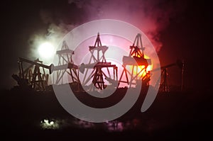 Oil pump oil rig energy industrial machine for petroleum, Group oil rigs and brightly lit industrial site at night. Toned.Backgrou