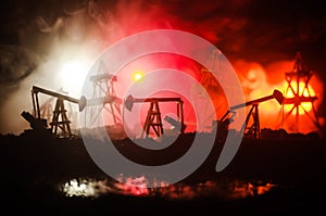 Oil pump oil rig energy industrial machine for petroleum, Group oil rigs and brightly lit industrial site at night. Toned.Backgrou