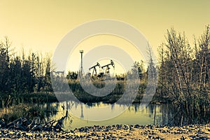 Oil pump rig. Oil and gas production. Oilfield site. Pump Jack are running. Drilling derricks for fossil fuels output