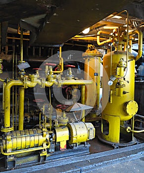 Oil pump, yellow pipes, tubes, machinery at power plant