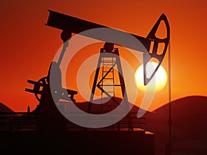 Oil pumping jack silhouette against the sunset