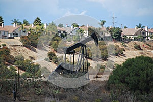 Oil pumpjack derrick next to residential neighborhood