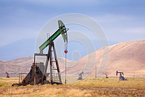 Aceite tacones altos sobre el El gran campo petrolero en un gran montanas 