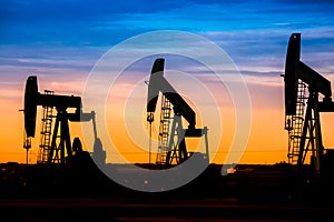 Oil pumps at oil field with sunset sky background