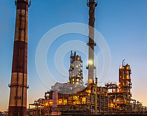 Oil refinery industrial plant or factory at sunset, storage distillery tanks and steel pipeline, modern petrochemical technologies