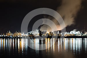 An oil refinery near a river at night
