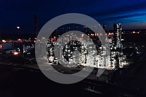 Oil refinery at night lit. Construction of an oil industrial fac