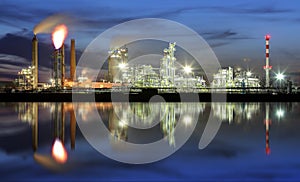 Oil refinery at night with reflection in water