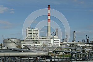 Oil refinery and petrochemical industrial plant against blue sky, oil and gas processing tanks, industrial area.