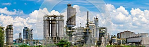 Oil Refinery Plant Behide Row Of Tree And Blue Sky With Cloud