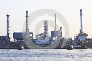 Oil refinery plant beside river in morning light