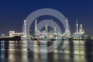 Oil refinery at twilight with river reflexion