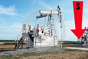 Oil rig in the field and a red down arrow with a dollar sign.