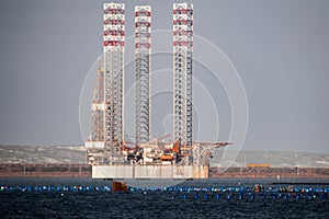 Oil rig moored in harbor with legs lifted