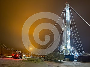 An oil rig in the north of Russia at night in winter on an illuminated site