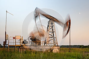 Oil rig silhouette working at sunset. Blur at slow shutter speeds