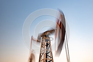 Oil rig silhouette working at sunset. Blur at slow shutter speeds