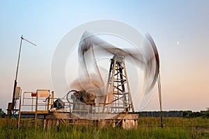 Oil rig silhouette working at sunset. Blur at slow shutter speeds